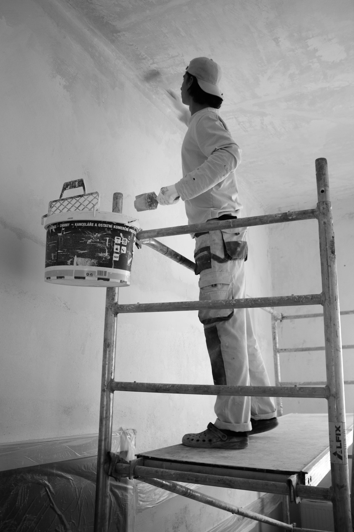 Person beim Streichen einer Wand mit Farbroller