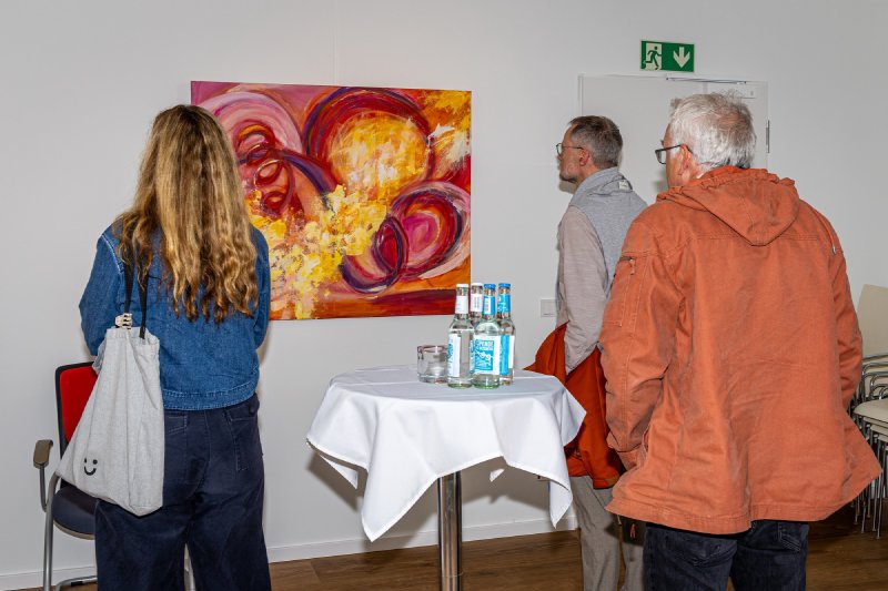 Zwei Gäste betrachten ein Gemälde der Ausstellung