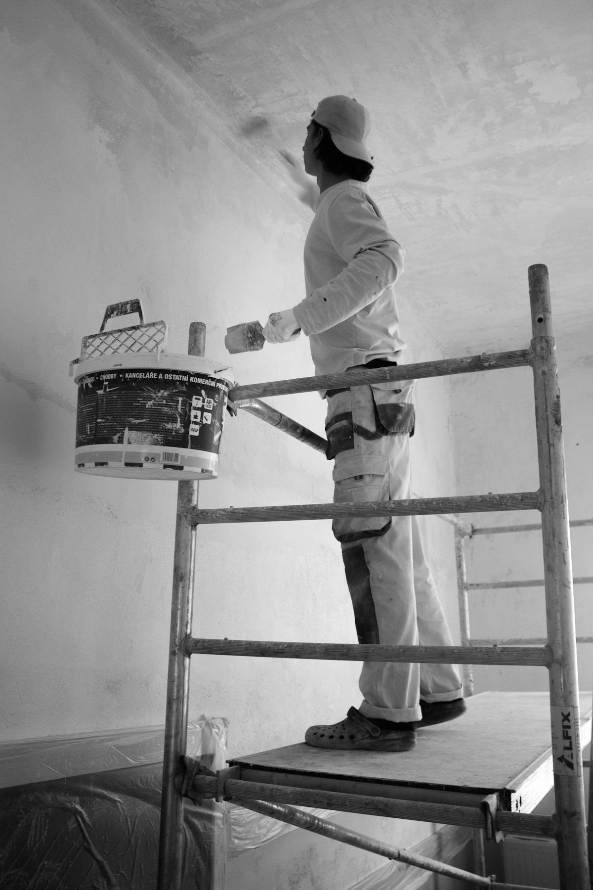 Person beim Streichen einer Wand mit Farbroller